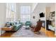 Bright living room featuring high ceilings, large windows, a cozy fireplace and hardwood flooring at 3962 Hoyt Ct, Wheat Ridge, CO 80033