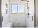Tiled shower featuring a built-in bench, window, and recessed shelving at 3962 Hoyt Ct, Wheat Ridge, CO 80033