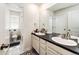 Bright bathroom features a double sink vanity, a mirror, and a toilet in a separate room at 24505 E Ada Pl, Aurora, CO 80018