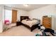 Bedroom features a large window, neutral carpeting, and wood-framed bed at 24505 E Ada Pl, Aurora, CO 80018