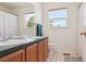 Bright bathroom featuring double sinks, neutral walls, and modern fixtures at 10795 Quail Creek E Dr, Parker, CO 80138