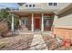 Charming front porch with brick columns and a bright red front door at 10795 Quail Creek E Dr, Parker, CO 80138