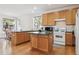 Kitchen with wood cabinets, a center island, and natural light at 10795 Quail Creek E Dr, Parker, CO 80138