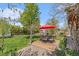 Expansive back yard featuring patio with dining set, lush lawn, and mature trees providing shade at 6731 Devinney St, Arvada, CO 80004