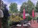 Charming backyard patio with an outdoor dining set, flower garden, and shade umbrellas at 6731 Devinney St, Arvada, CO 80004