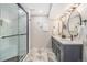 Bright bathroom featuring a double vanity, modern fixtures, and a tiled shower with a glass door at 6731 Devinney St, Arvada, CO 80004