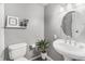 Well lit bathroom featuring a toilet, sink, mirror, and an indoor plant for decoration at 6731 Devinney St, Arvada, CO 80004