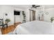 Bright bedroom featuring hardwood floors, a barn door, and a comfortable bed at 6731 Devinney St, Arvada, CO 80004