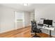 Bedroom with a window for natural light, hardwood floors, and shelving along the wall at 6731 Devinney St, Arvada, CO 80004