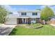 Well-maintained two-story home featuring a lush front lawn, brick accents, and an attached two-car garage at 6731 Devinney St, Arvada, CO 80004