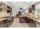 Updated kitchen with stainless steel appliances, granite counters, and view into adjacent living area at 6731 Devinney St, Arvada, CO 80004