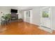 Cozy living room with a brick fireplace, hardwood floors, and a well-lit atmosphere at 6731 Devinney St, Arvada, CO 80004