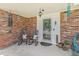 Inviting front porch with brick wall, rocking chairs, and potted plants at 6731 Devinney St, Arvada, CO 80004