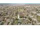 Aerial view showcases a neighborhood with mature trees, residential homes, and clear streets under a bright sky at 6133 S Sterne Cir, Littleton, CO 80120