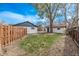 Fenced backyard with grass and trees, offering a private outdoor space at 6133 S Sterne Cir, Littleton, CO 80120