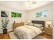Nicely furnished bedroom features hardwood floors, natural light, and a cozy bed for a relaxing ambiance at 6133 S Sterne Cir, Littleton, CO 80120