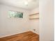 Bright bedroom features hardwood floors, a window, and shelves for a clean and organized space at 6133 S Sterne Cir, Littleton, CO 80120
