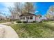 Charming home featuring a well-manicured lawn and mature tree, creating a welcoming and picturesque exterior at 6133 S Sterne Cir, Littleton, CO 80120