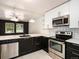 Modern kitchen with stainless steel appliances, white quartz countertops, and contemporary black and white cabinetry at 6133 S Sterne Cir, Littleton, CO 80120