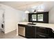 Well-lit kitchen features stainless steel appliances, a dishwasher, and black cabinets with bright countertops at 6133 S Sterne Cir, Littleton, CO 80120