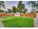 Expansive backyard with a lush lawn, a detached garage, and a wood fence at 150 S Osceola St, Denver, CO 80219