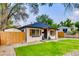 Inviting home with a well-manicured lawn, a wooden fence, fresh landscaping, and a charming pergola covered entry at 150 S Osceola St, Denver, CO 80219