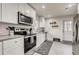 Modern kitchen featuring all white cabinets, stainless steel appliances, and stylish tile backsplash at 150 S Osceola St, Denver, CO 80219