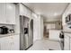 Modern kitchen featuring all white cabinets, stainless steel appliances, and an eat-in dining area at 150 S Osceola St, Denver, CO 80219
