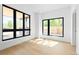 Sunlit bedroom with hardwood floors and large windows overlooking green trees at 2190 Vine Ave, Boulder, CO 80304