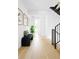 Bright hallway with light wood floors, modern art, bench seating, and view to other rooms at 2190 Vine Ave, Boulder, CO 80304