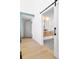 Bright hallway with light wood floors and a view into a bathroom with sliding barn door at 2190 Vine Ave, Boulder, CO 80304