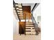 Modern staircase with light wood treads, black metal railings, and a wood accent wall at 2190 Vine Ave, Boulder, CO 80304