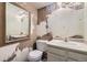 Outdated bathroom with toilet, sink, and partially removed wallpaper and peeling paint at 2370 Redwood Ave, Lafayette, CO 80026