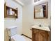 Bathroom features a toilet, vanity with sink, mirror, and a small storage shelf at 2370 Redwood Ave, Lafayette, CO 80026