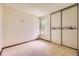Bedroom with neutral carpet, a window with treetop view, and a sliding closet at 2370 Redwood Ave, Lafayette, CO 80026