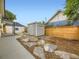 Backyard with stone walkway, a grey storage shed, and a new fence at 1694 Xanthia St, Denver, CO 80220