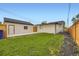 This backyard offers a well-maintained lawn between the home and detached garage at 1694 Xanthia St, Denver, CO 80220