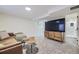 Cozy basement entertainment area with a modern TV console and adjacent full bathroom at 1694 Xanthia St, Denver, CO 80220
