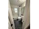 Bright bathroom featuring black hexagon tile flooring and a shower/tub combo with marble-patterned walls at 1694 Xanthia St, Denver, CO 80220