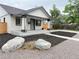 Charming exterior view of the home's front yard featuring mature trees, mulched garden, and well manicured landscaping at 1694 Xanthia St, Denver, CO 80220
