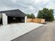 Large garage with extended parking pad and a privacy fence that encloses a small yard at 1694 Xanthia St, Denver, CO 80220