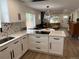 Modern kitchen with white cabinets that opens to living area at 1694 Xanthia St, Denver, CO 80220