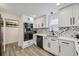 Modern kitchen featuring white cabinets, stainless steel appliances, and stylish backsplash and light fixture at 1694 Xanthia St, Denver, CO 80220