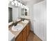 Bathroom featuring double sinks with wood cabinets, tile backsplash, and modern fixtures at 10674 Cherrington St, Highlands Ranch, CO 80126