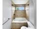 Bright bathroom with a shower-tub, decorative tiles, and a window for natural light at 10674 Cherrington St, Highlands Ranch, CO 80126