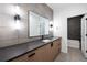 Bathroom vanity with wood cabinets, dark countertop, and modern lighting at 5031 Moss Pl, Golden, CO 80403
