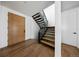 Modern staircase with wood steps, sleek black metal railings, and a contemporary wood front door at 5031 Moss Pl, Golden, CO 80403