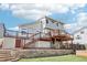 Two-story home with a spacious wooden deck featuring glass railings and a stone retaining wall at 11035 W Grand Pl, Littleton, CO 80127