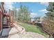 Landscaped backyard with wooden stairs, grassy area, and privacy fence at 11035 W Grand Pl, Littleton, CO 80127
