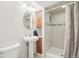 Bathroom features a pedestal sink, tiled shower with glass door, and decorative wall accents at 11035 W Grand Pl, Littleton, CO 80127